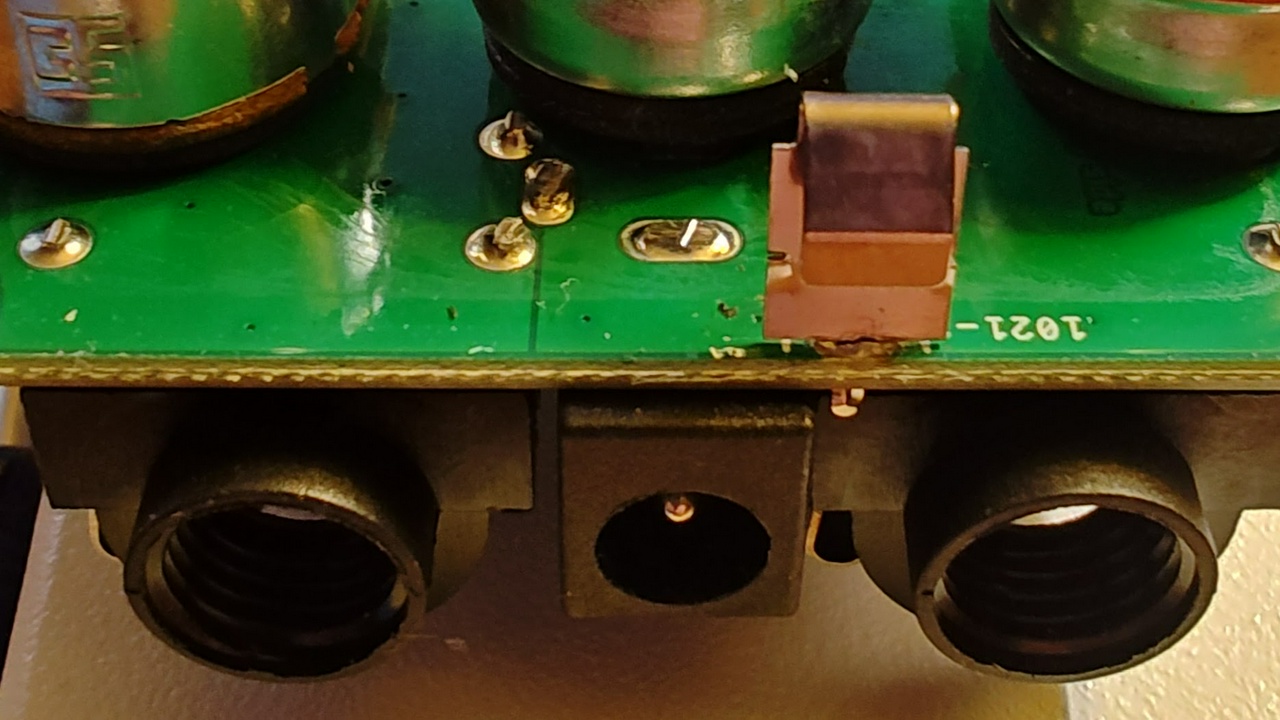 Photo of the side of the Wampler Triumph circuit board showing the Keystone 1021-1 battery clip Wampler uses.  The spring part of the clip extends past the edge of the board.
